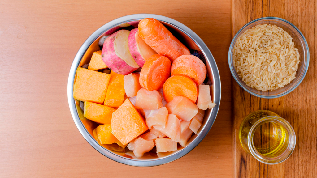 Uma tigela de legumes e arroz em uma mesa de madeira.
