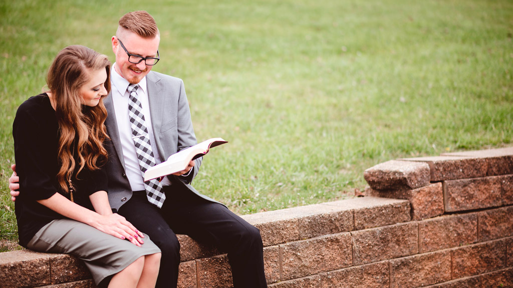 um homem e uma mulher lendo um livro juntos