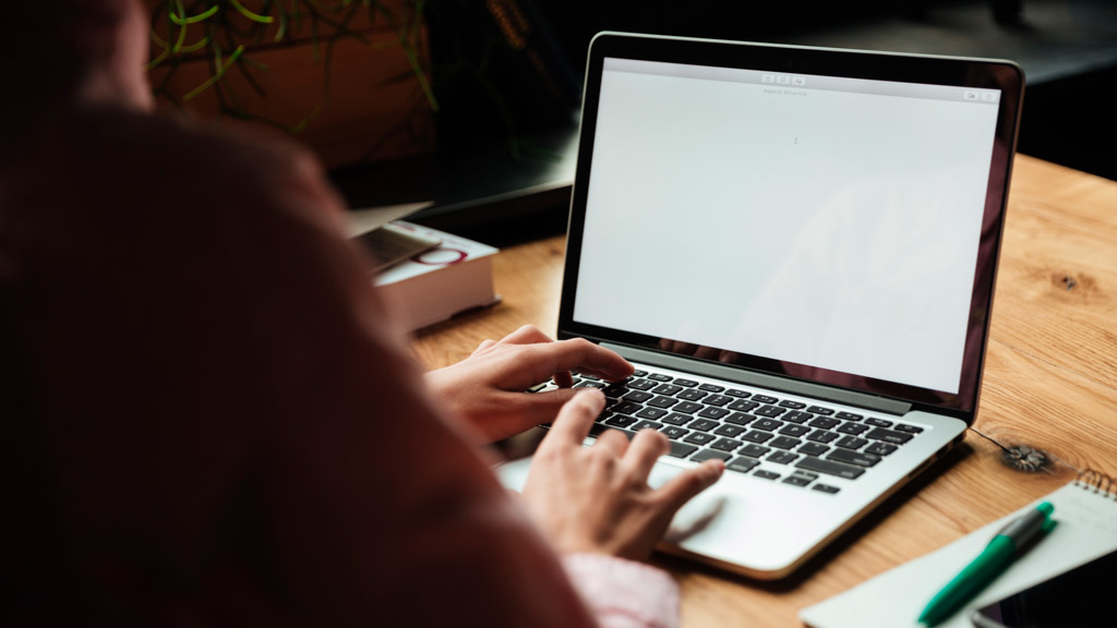uma mulher digitando em um laptop