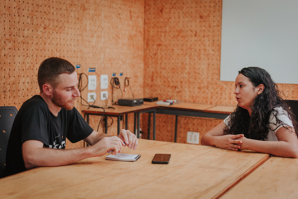 Duas pessoas conversando em uma sala de reuniões de coworking