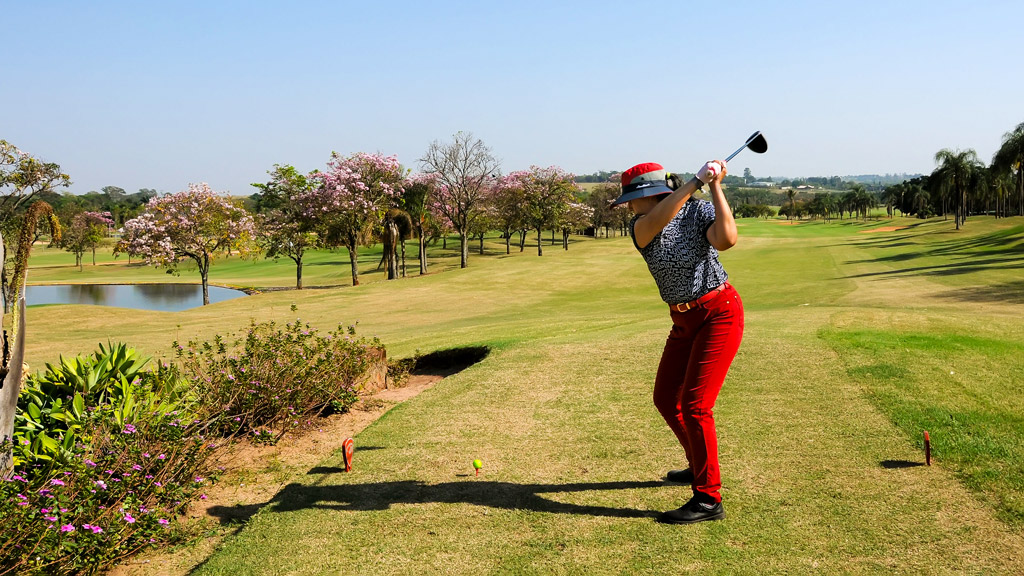 Uma mulher jogando golfe.