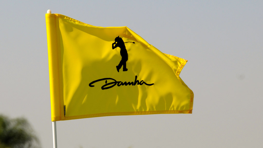 Uma bandeira amarela com a representação de uma pessoa jogando golfe e a palavra "Damha" tremulando