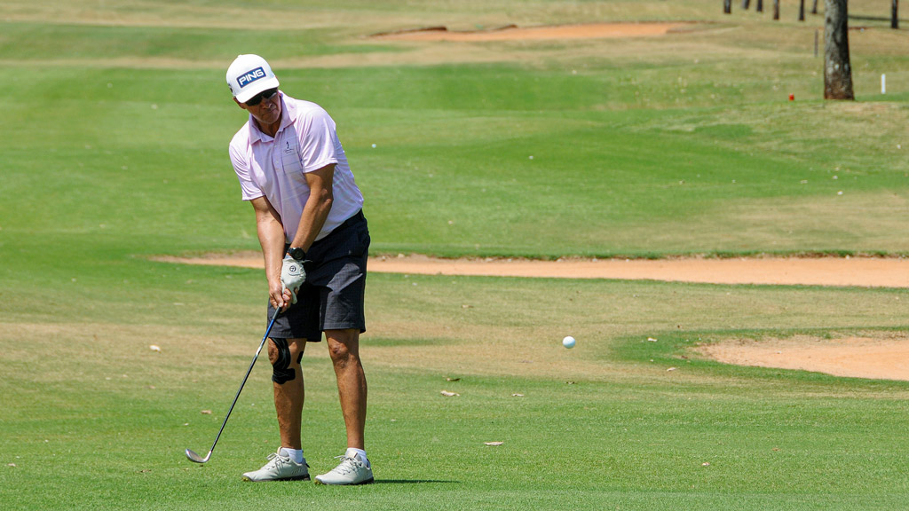Um homem jogando golfe.
