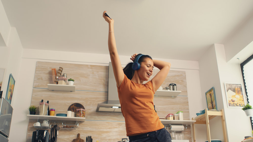 Mulher feliz dançando na cozinha.