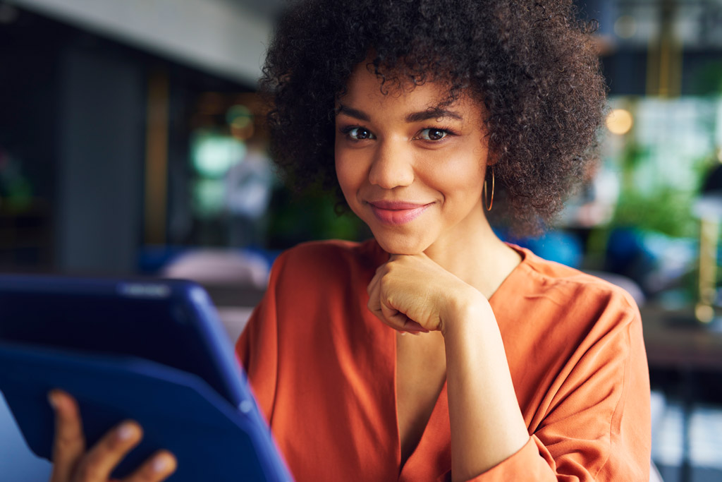Uma mulher jovem sorridente segurando um tablet