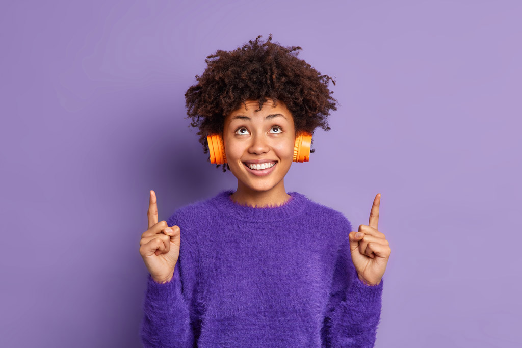 Mulher sorridente com fones de ouvido.