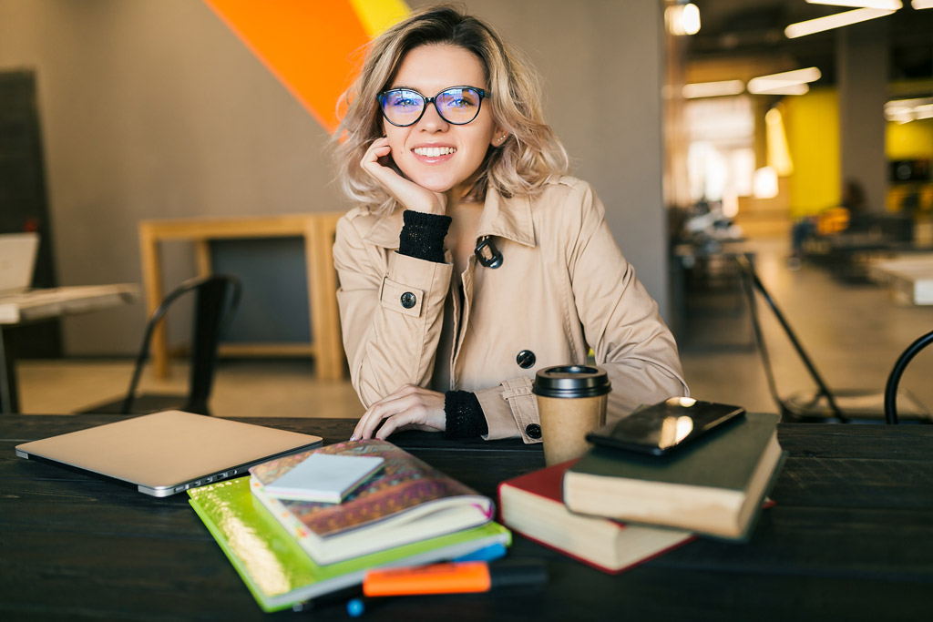 Uma mulher sorrindo atrás de alguns livros