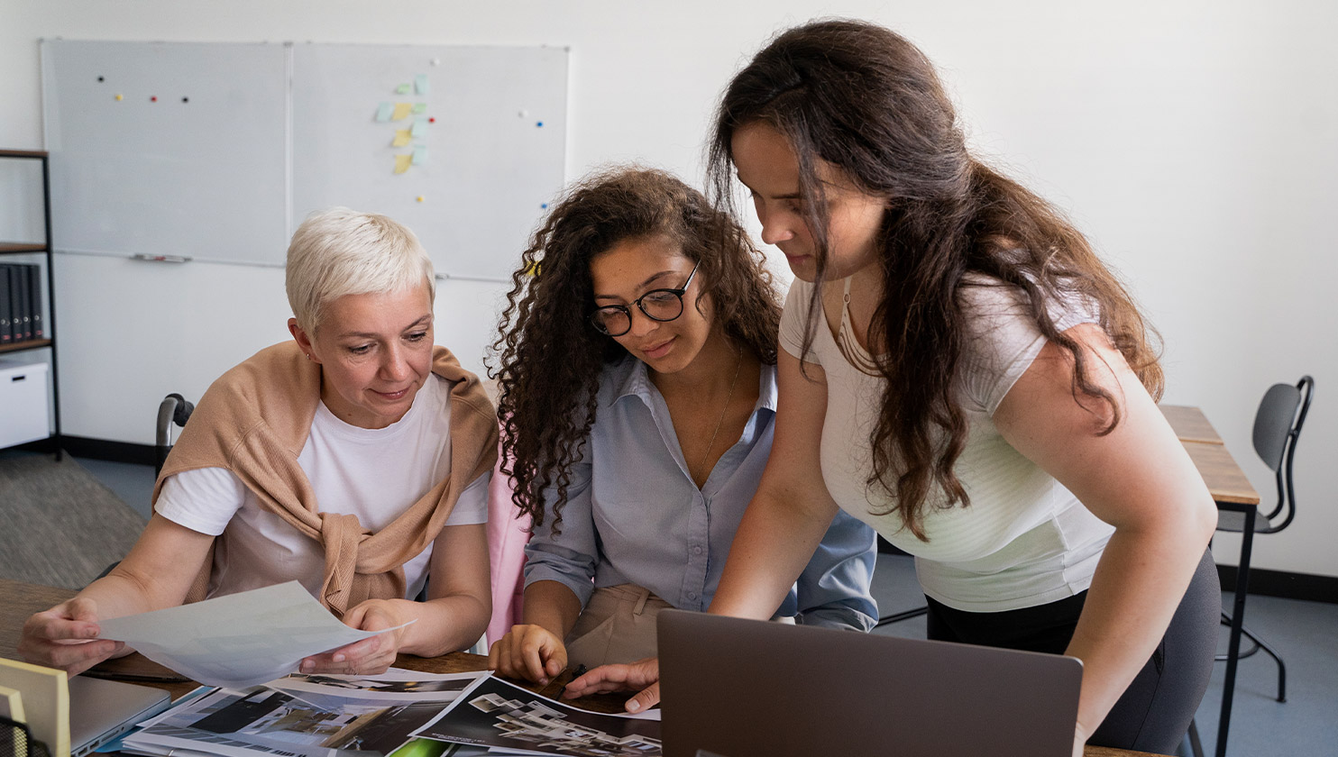 Três mulheres trabalhando na edição de um livro