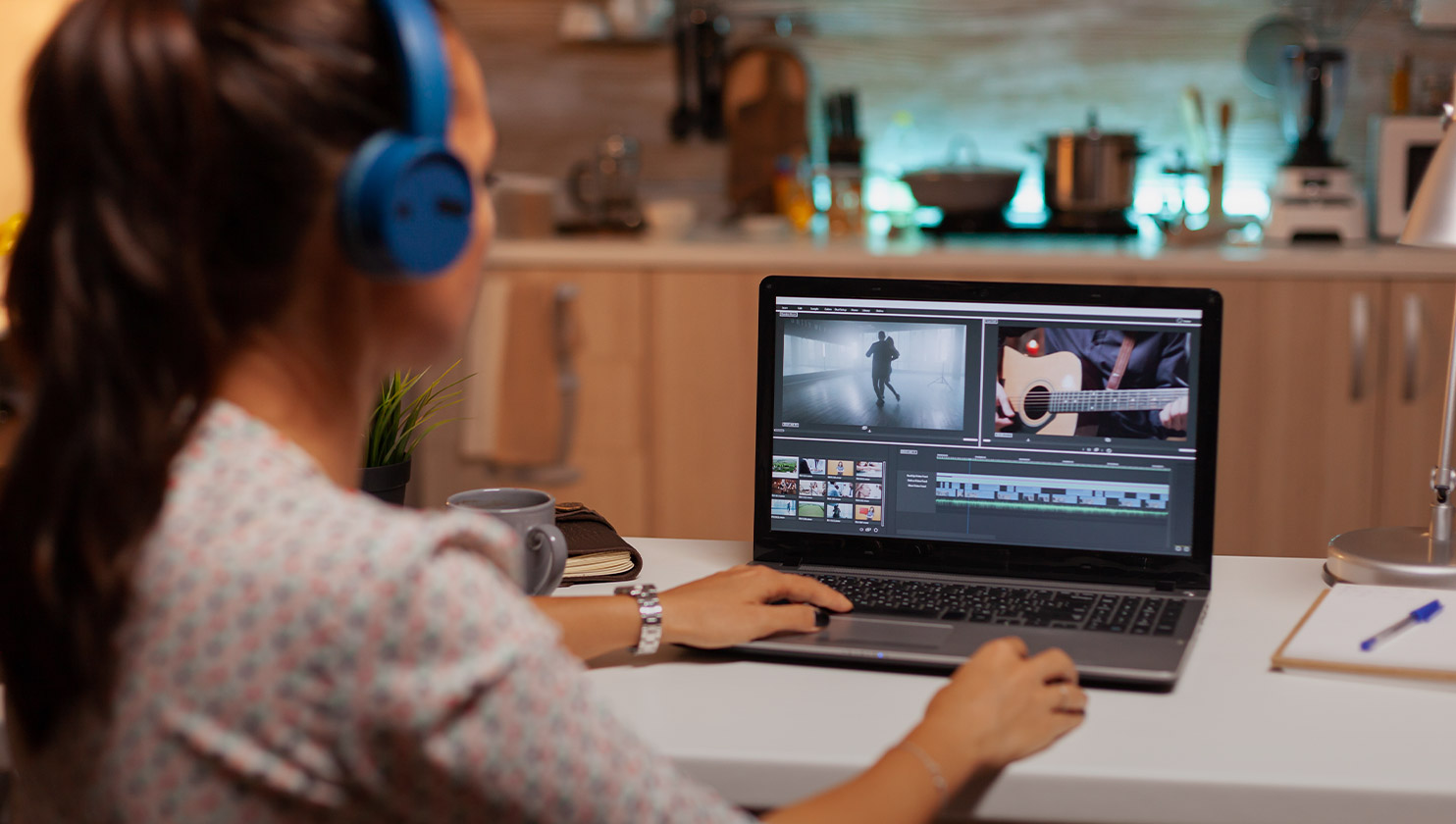 uma mulher trabalhando com edição de vídeo em seu laptop