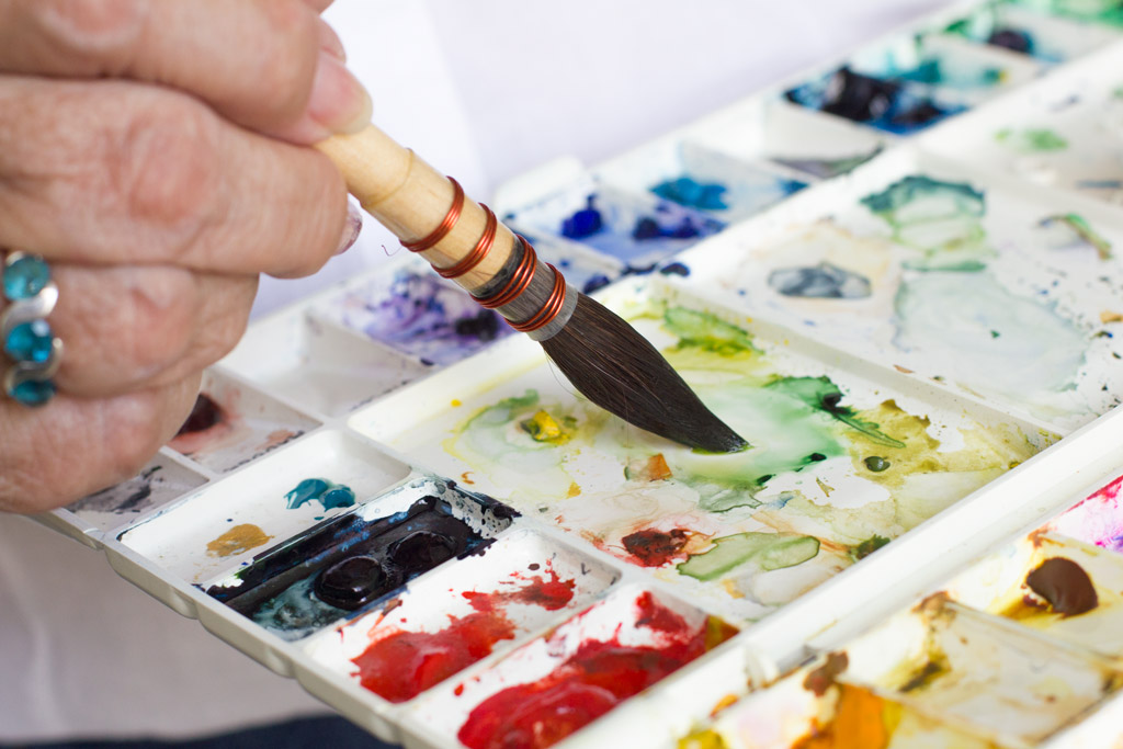 Detalhe de um pincel no godê de aquarela.